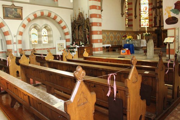 Kirchenbänke, teilweise mit Bändern gesperrt