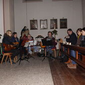 Gitarrenspielerinnen und Flötenspieler im Halbkreis im Seitenschiff der Kirche