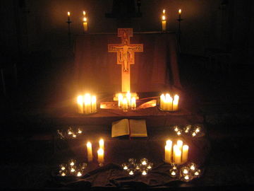 Franziskuskreuz und Kerzen vorm Altar